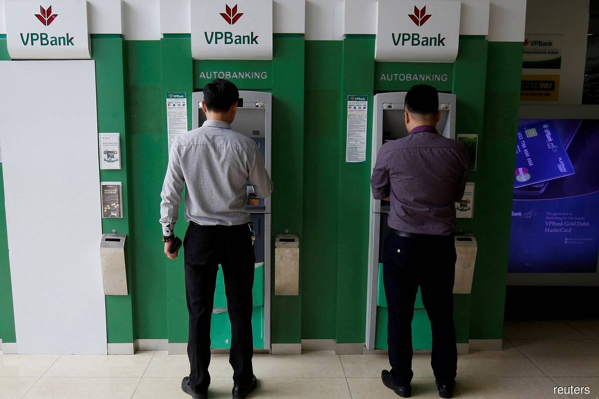 Men withdraw money from an ATM at a branch of Vietnam Prosperity Joint Stock Commercial Bank in Hanoi November 15, 2017. (Reuters pic)